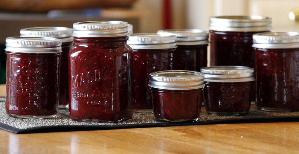 Batch of raspberry with blackberry jam in jars with lids