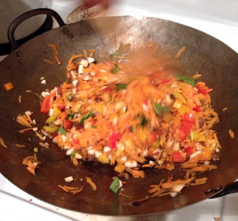 Stirring veggies and sauce for fried basil rice